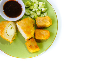 mpek-mpek or pempek. fish and tapioca served on a green plate with rich sweet and sour sauce called kuah cuka or vinegar sauce. Isolated on white background