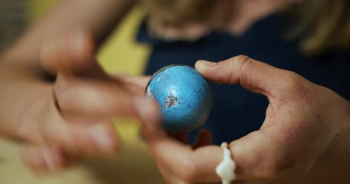 Close up on woman hands decorating easter egg