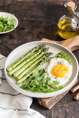 Healthy homemade breakfast with asparagus, fried egg and arugula. quarantine healthy eating concept. keto diet