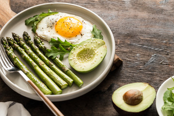 Healthy homemade breakfast with asparagus, fried egg, avocado and arugula. quarantine healthy eating concept. keto diet