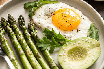 Healthy homemade breakfast with asparagus, fried egg, avocado and arugula. quarantine healthy eating concept. keto diet