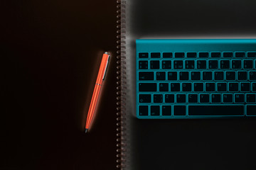 Obraz premium Abstract business workplace. Wireless computer keyboard, notebook and pen on business office table