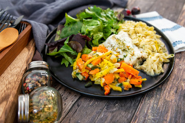 cod fish with vegetables, small vegetables and marine sauce