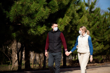 Obraz premium Young European man and woman in protective disposable medical mask walking outdoors afraid of dangerous NCoV 2019 influenza coronavirus mutated and spreading in China