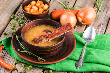 Pea soup with bacon on wooden boards