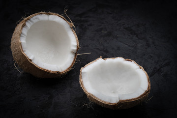 Fresh cracked coconut on black backround