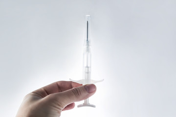syringe with a microchip in his hand on a light background close