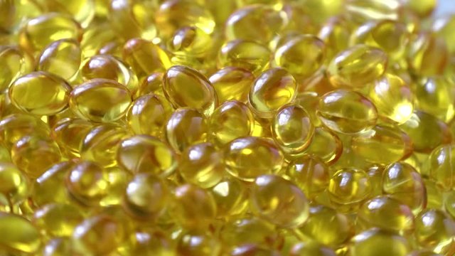 Golden background capsules Close up food supplement oil filled capsules suitable vitamin A, vitamin D3, fish oil, omega 3, 6, 9, evening primrose, borage oil, flax seeds oil, vitamin D, vitamin E