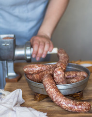 Woman cooks homemade meat sausages