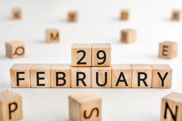 February 29 - from wooden blocks with letters, important date concept, white background random letters around