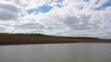 Fototapeta premium Forest and field near the river. Blue sky. Side view