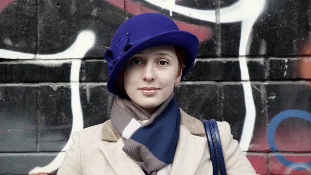 Charming model happy face glamour looking flirt man. Attractive girl blue hat look at camera with cheerful smile closeup carefree face background graffiti street 4K. Cute woman stand style hat city.