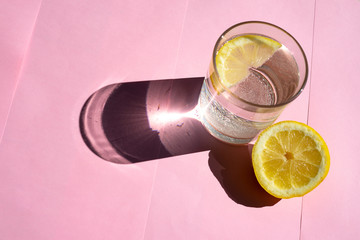 Lemon tonic on a pink background. Lemon tonic concept.
