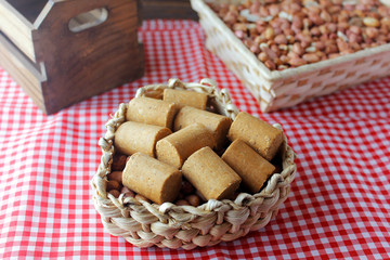 Peanut candy (paçoca or pacoca) traditional Brazilian sweet based on peanuts, manioc flour and sugar on a rustic wooden table