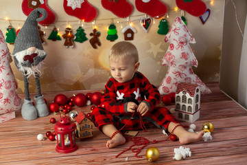 a little boy will play with Christmas toys. children's new year photo session. a child on Christmas morning