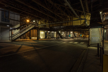 Opposite stairwells leading up to overhead subway trains at night in downtown Chicago