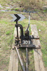 Railway arrow in black with a lever and pointer in Russia. The device for the transfer of rails at intersections for trains. Technical element of the railway industry.