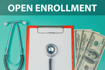 Open enrollment, medicine concept. Stethoscope, money, notepad and money on a green background.
