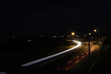 Fototapeta na wymiar Escrevendo com faróis e lanternas na estrada a noite