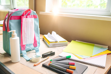 Back to school after quarantine concept. Backpack with school supplies and sanitizer and medical...