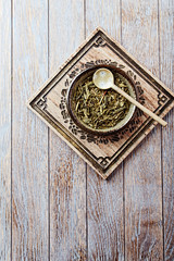 Dried Green Tea Leaves on Bright Background. Top view.	