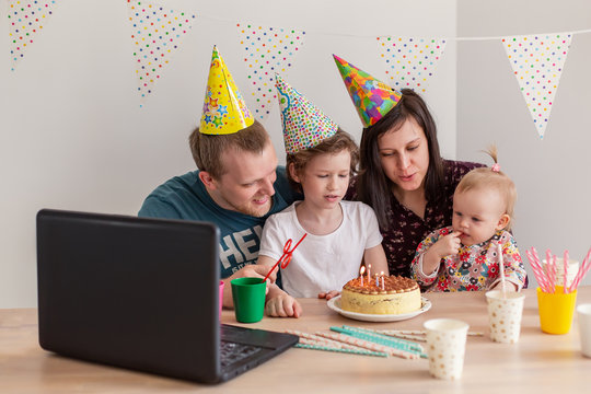 Big family celebrates a birthday online. Mom dad kids at home  video call self-isolation. Party on laptop new technology gadgets. Coronavirus quarantined. Joy happiness positive congratulations cake