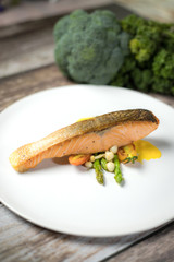 Salmon Steak.Grilled salmon with yellow cream sauce and asparagus on a white plate