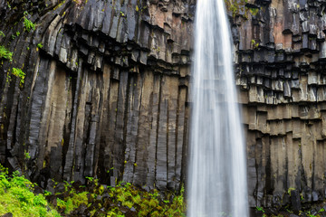 Svartifoss waterfall and basalt columns shaped over the years in the skaftafell national park in the icelandic highlands. Texture, holiday and travelling concept.