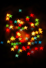 Bokeh stars colored lights on black background, Christmas