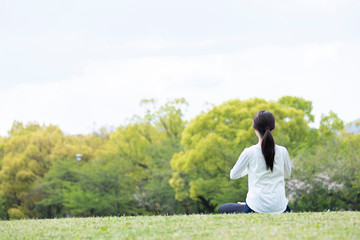 緑豊かな公園でヨガのポーズをとる若い女性