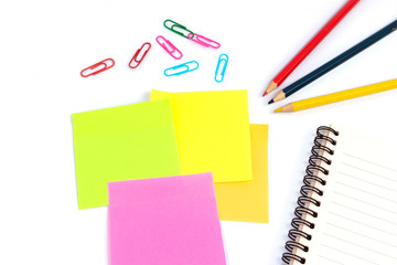 color pencils and notebooks, sticky note, paper clip in many colors and placed on a white background in the home studio. This concept is used as an illustration for education idea