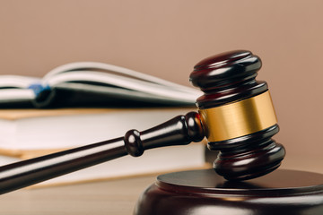 Judge gavel and laws books on a wooden table.