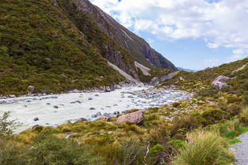 Fototapeta na wymiar A picturesque green valley in the Southern Alps. A river among the hills. Not far from Hooker Lake. South Island, New Zealand.