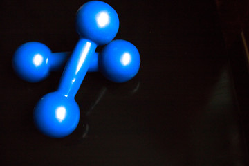 Blue dumbbells on a black background
