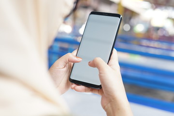 Woman hand holding black smartphone with blank screen for mock up. Cropped shot view of woman's hands holding a smartphone with blank copy space screen for your text message or information content.