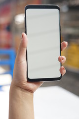 Woman hand holding black smartphone with blank screen for mock up. Cropped shot view of woman's hands holding a smartphone with blank copy space screen for your text message or information content.