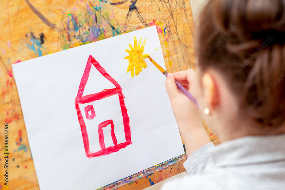 Poster Child is drawing house with watercolors on the easel.