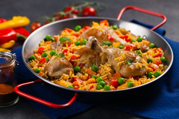 Arroz con pollo. Baked pieces of chicken with bone, rice with paprika and peas.