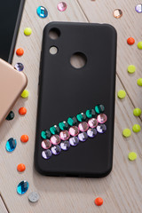 Black phone case decorated with colorful rhinestone stripes