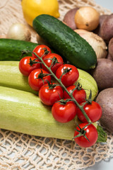 Organic vegetables lie on a reusable bag on a gray background. Healthy clean diet and detox.
