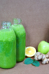 Glass bottles filled with fresh kale and ginger green smoothie