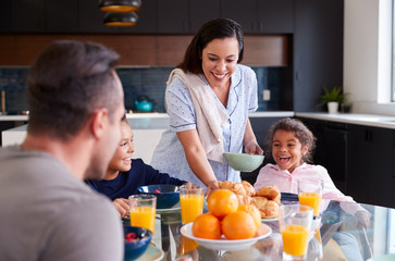 Hispanic Family Sitting Around Table Eating Breakfast Together