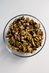 
walnuts in a glass plate on a white background