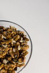 
walnuts in a glass plate on a white background