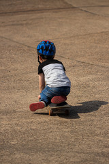 Little boy playing on skateboard in the street