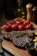 T-bone steak with baked tomato and french fries