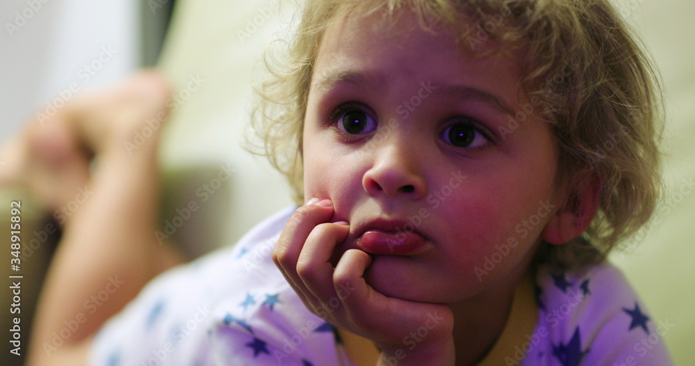 Wall mural candid little toddler boy face watching tv at night