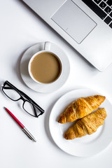 Coffee break in office on desk with laptop top view