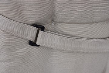 black plastic snap hook latch on the harness on the gray fabric of the backpack