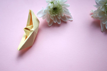 Paper boat and flowers on a pink background